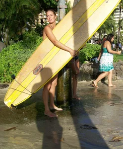 Skinny blonde surfer on the beach in little bikini