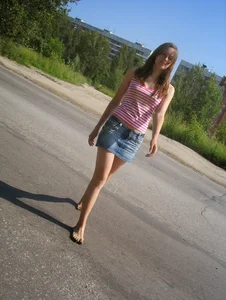 Skinny Teen in a Denim Skirt Walking Barefoot on Asphalt