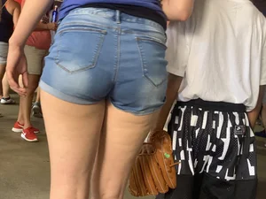 Bunch of girls in various outfits at a Cardinals baseball game