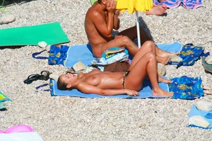 Nudist couple on the beach, girl has amazing tits and nice ass in a thong