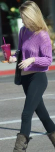 Beautiful skinny blonde in tight leggings and purple crop top showing sexy stomach