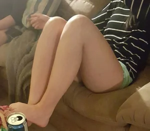 Barefoot Girl in Mini Shorts Sitting in a Couch With Her Feet on Table