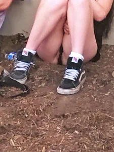 Girl in Mini Shorts Sitting on the Ground Lip-Slip Creepshot