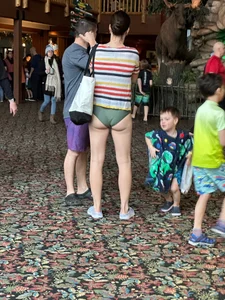 Candid milf in a swimsuit standing in a hall, long slim legs