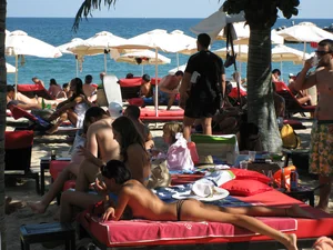 Topless cutie at the beach with a tight little ass in a thong