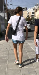 Cute skinny teen in shorts walking down the street