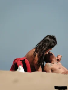 Topless lady on the beach in a gold thong with a nice ass