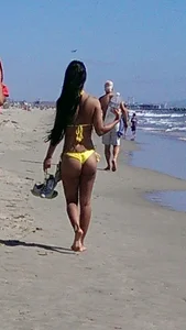 Beach babe with a nice ass and big tits in yellow thong bikini