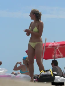 Sexy blonde on the beach in a yellow thong bikini