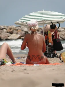 Tattooed blonde with big tits topless and in thong