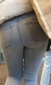 Girl with a tight ass in grey jeans going up the escalator