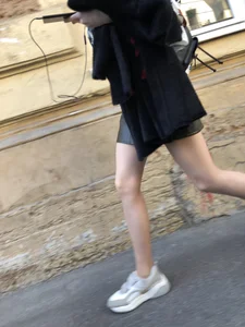 Nice slim legs of a candid girl wearing a leather skirt