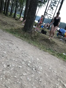 Cute Barefoot Girl in a Black Body Swimsuit Walking on a Road