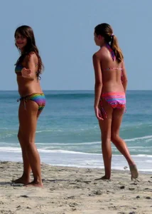 Two nice bikini girls walking on beach