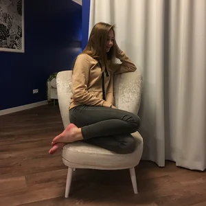 Cute Girl in Tight Jeans with Bare Feet Sitting in the Couch Candid