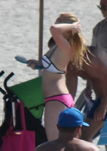 Skinny blonde girl on the beach in her pink and white bikini