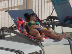 Hot milf sunbathing in a thong by pool and swimming