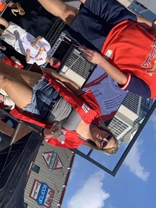 Bunch of girls in various outfits at a Cardinals baseball game