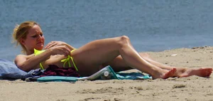 Sexy ass blonde milf on the beach in a thong with cameltoe and bending over
