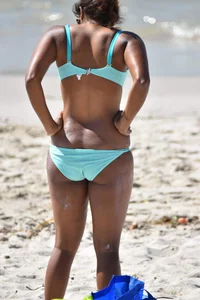 Tanned brunette girl on the beach in a bikini