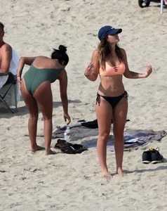 Big boobed babe with pokies in a bikini on the beach with friends
