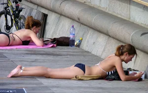 Girl in Swimsuit Lying on the Stone Embankment Street Candid
