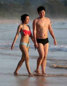 Cute Asian in bikini on the beach with her boyfriend