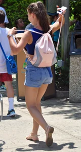 Beautiful girl in a blue top and denim shorts