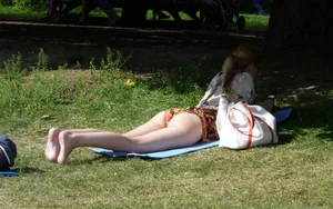 Girl with Nice Legs in Swimsuit Lying on the Park Lawn Candid Photo