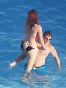 Sexy red haired girl in pink and black bikini at the pool