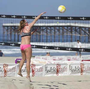 Hot girls playing beach volleyball in bikinis and shorts