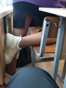Legs of candid college teens wearing pantyhose in class