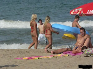 Sexy mom and daughter in red thongs at the beach
