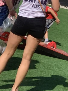 Bunch of girls in various outfits at a Cardinals baseball game