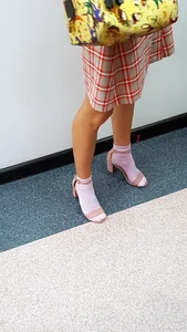 Girl in a Skirt and Sandals on Heels in White Socks with Nice Legs Closeup Creepshot