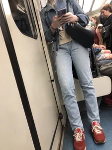 Cute girl in jeans standing in a subway train