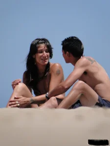 Topless lady on the beach in a gold thong with a nice ass