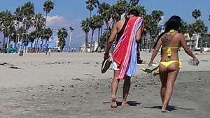 Beach babe with a nice ass and big tits in yellow thong bikini