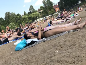 Gorgeous milf rubbing sun lotion in her skin at the beach, with a couple of her milf friends