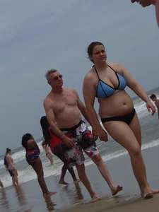 Big boobed girl on the beach in blue and black bikini