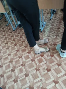 College candid teen wearing pants and sandals with extremely pale skin on her feet