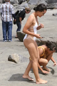 Sexy brunette babe on the beach in a white swimsuit