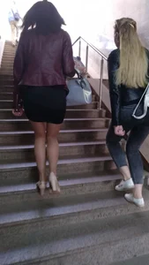 Hot girl walking up the stairs, wearing a skirt, pantyhose and high-heeled shoes
