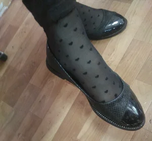 Feet in Flats and Black Pantyhose With Hearts Pattern Closeup in College Classroom