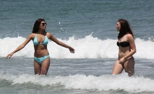 Brunette and redhead on the beach in bikinis looking sexy