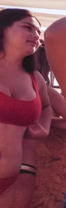 Thick brunette on the beach with friends in red bikini