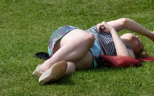 Girl in a Skirt Lying on the Grass Candid Photo