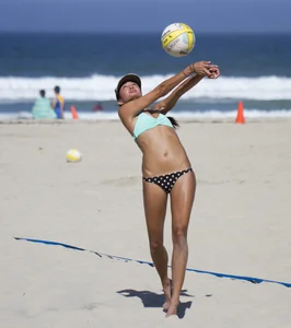 Hot girls playing beach volleyball in bikinis and shorts