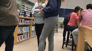 Blonde teen shopping at an Apple store in tight grey leggings