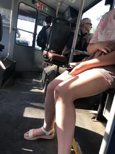 Young Girl in Sandals and Shorts in a Public Bus